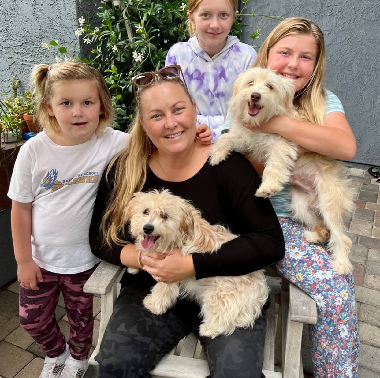 A family with two cream doodle puppies on delivery day