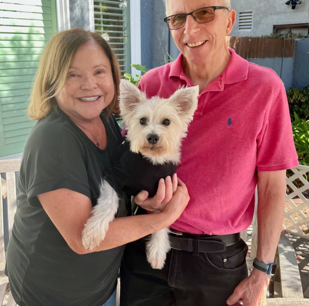 A couple with their white terrier at home